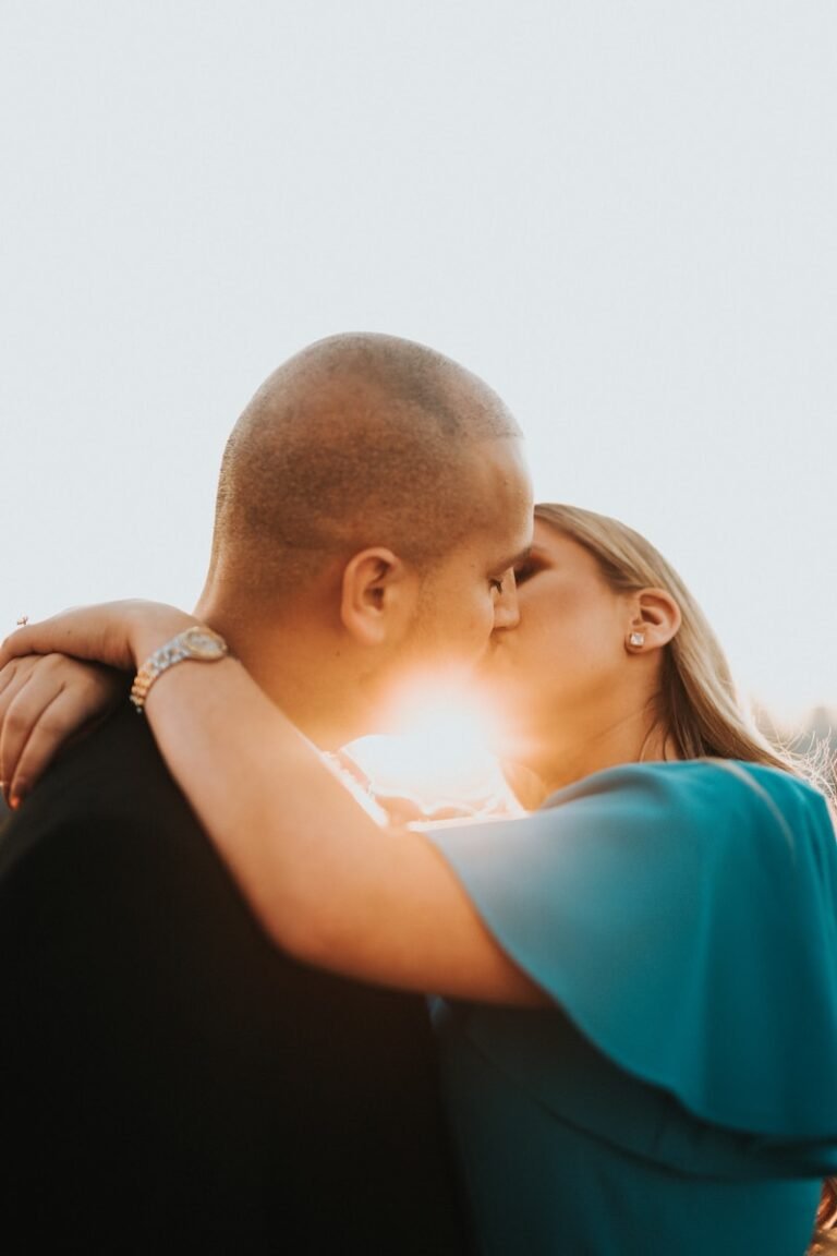 man in blue shirt kissing woman in black shirt