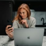 a woman sitting in front of a laptop computer